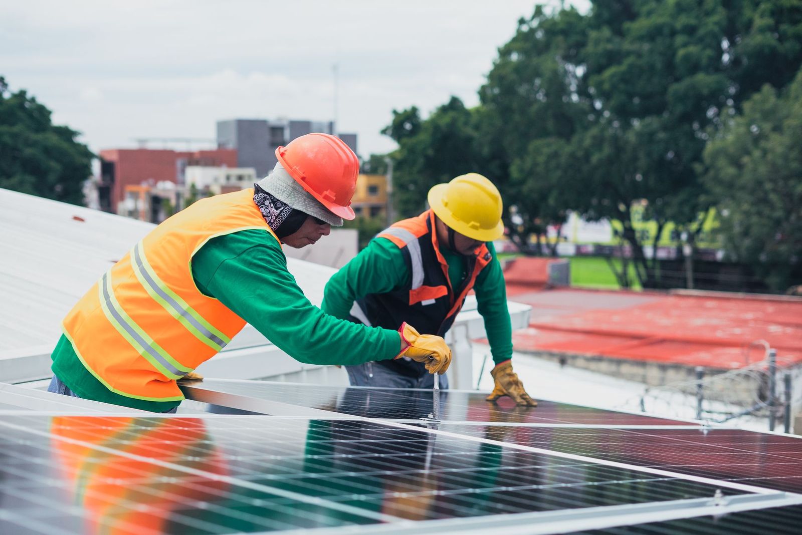 Two solar technicians securing a rooftop solar panel